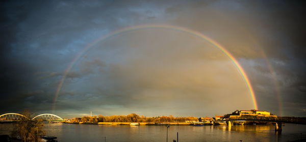 Rainbow over city against sky