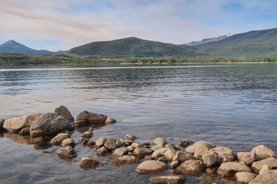 Rocks in lake against sky