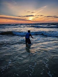 Silhouette man on beach against sky during sunset