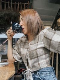 Low angle view of woman drinking coffee while sitting at home