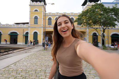 Self portrait of smiling woman in front of the public market of florianopolis santa catarina, brazil