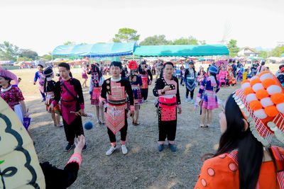 Group of people in traditional clothing against sky