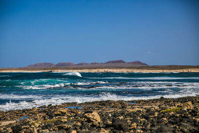 Scenic view of sea against clear blue sky