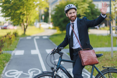 Portrait of young man riding bicycle on road