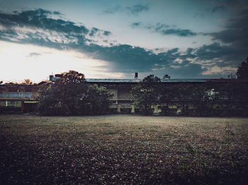 Houses on field by buildings against sky