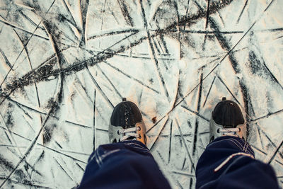 Low section of man ice skating in snow