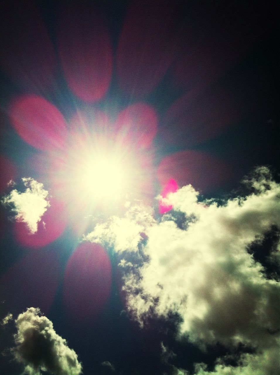 low angle view, sun, sky, lens flare, sunbeam, sunlight, bright, cloud - sky, beauty in nature, nature, outdoors, multi colored, pink color, no people, tranquility, blue, day, sunny, cloud, glowing