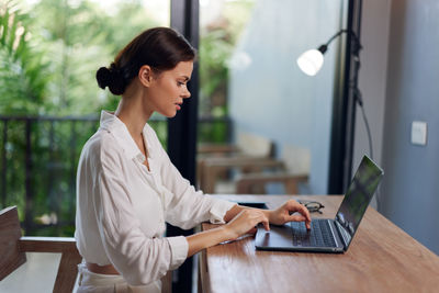Businesswoman using laptop at table