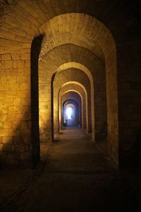 Empty corridor in illuminated tunnel