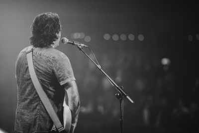 Rear view of man singing outdoors