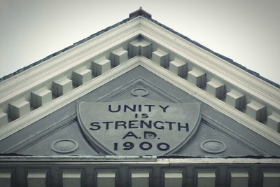 Low angle view of text on building against sky