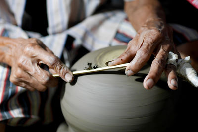 Cropped hands making pottery in workshop