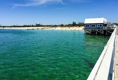 Stilt house in sea against sky