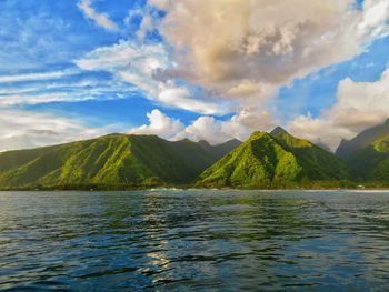 Scenic view of sea by mountains against sky