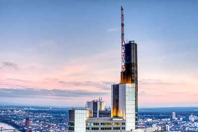 Modern buildings in city against sky during sunset