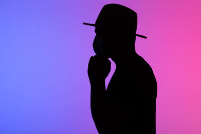 Silhouette of man against blue background