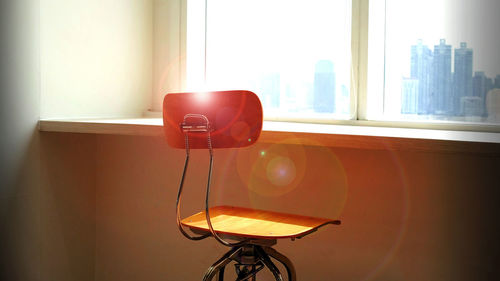 Front view empty chair with sunlight and window frame background, empty space for text