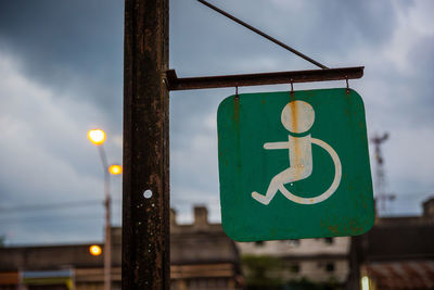 Close-up of road sign against sky