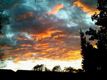 Silhouette of trees against cloudy sky