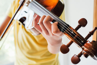 Midsection of boy playing guitar