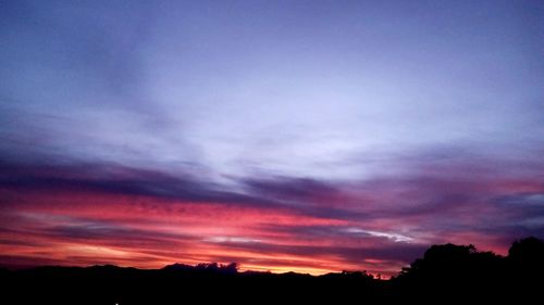 Scenic view of dramatic sky over silhouette landscape