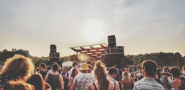 Crowd at music concert against sky