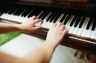 Close-up of hands playing piano