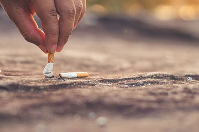 Men hand caught a burning cigarette causing smoke, concept stop smoking.