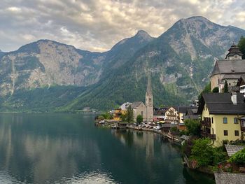 Town by lake and mountains against sky