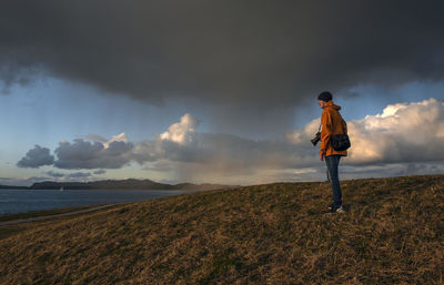 Rear view of man standing on land against sky