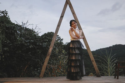 Rear view of woman standing on swing