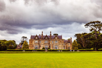 View of castle on field against cloudy sky