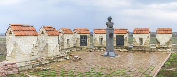 Statue of historic building against cloudy sky