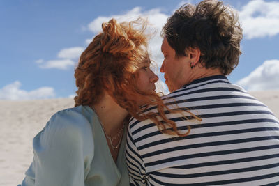 Rear view of woman and man with curly hair looking to each other