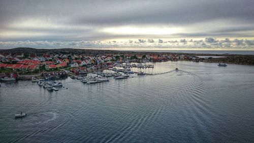 High angle view of boats moored at harbor against cloudy sky