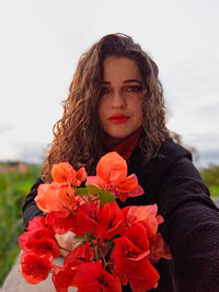 Portrait of young woman with red flower
