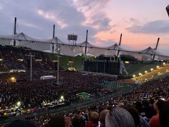 High angle view of crowd at concert against sky during sunset