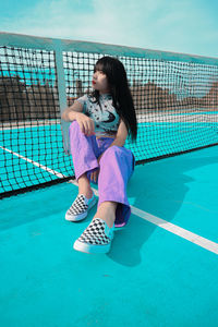 Full length of a girl sitting on swimming pool