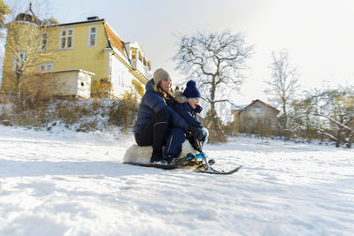 Mother with son sledging