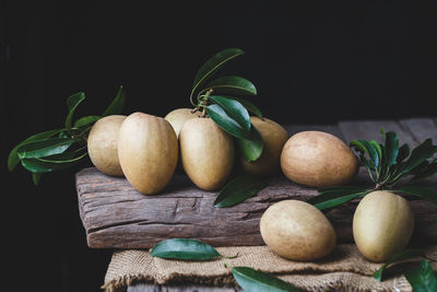 Close-up of fruits on table against black background