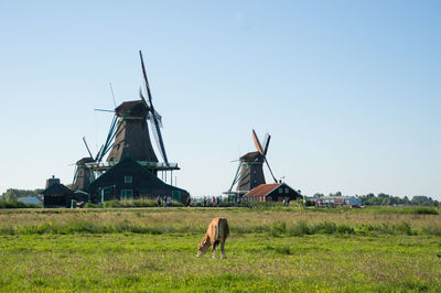 Traditional windmill on field against clear sky