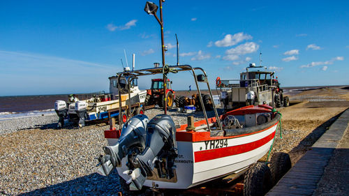 Ship moored on beach against sky