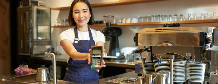 Portrait of young woman standing in cafe