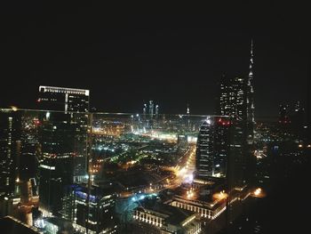 Illuminated cityscape against sky at night