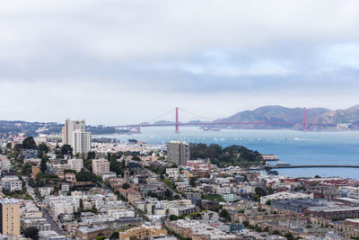 Aerial view of city buildings against cloudy sky