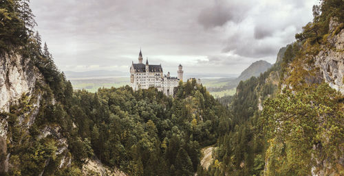 Hohenschwangau castle on mountain against cloudy sky