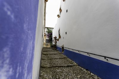 People on wall by sea against sky