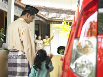 Father with daughter waving to grandfather and grandmother