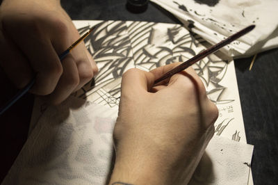 Close-up of human hands drawing on paper