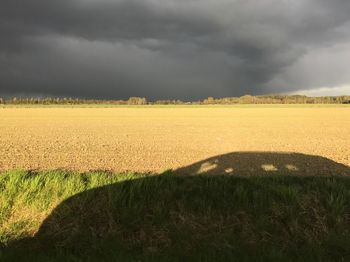 Scenic view of field against cloudy sky